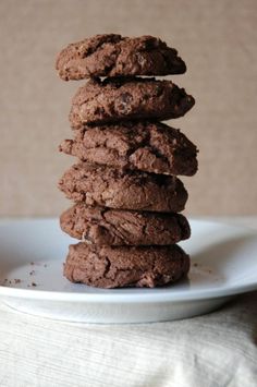 a stack of chocolate cookies sitting on top of a white plate