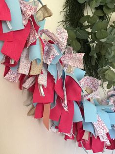 a wreath with red, white and blue ribbons hanging from it