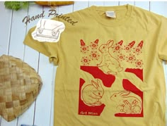 "= Rabbit Hole = They have a playroom, a powder room, and a nursery Rabbit Hole \" 100% American Grow Cotton Unisex T-shirt. This soft garment-dyed bunny tee, illustrated and hand-printed with Silk Screen by Mina Wilcox, was created with pure joy from her small art studio in California. We only use non-toxic water-based inks, ensuring they are safe for you and the Earth. Made from 100% ring-spun cotton, responsibly sourced from American farms, and carefully garment-dyed, this tee exudes a retro look and feel. DETAILS: One 100% American Grow Cotton Garment Dyed Short Sleeve T-shir *Garment dyeing offers a remarkable method for creating trendy and captivating apparel with a beloved, well-worn t-shirt appearance. This aesthetic is achieved by applying the dye to the clothing after it has unde Grow Cotton, Relax Lifestyle, Small Art Studio, Bunny T Shirt, Toxic Water, Pure Joy, Tshirt Art, Hand Screen Printed, Rabbit Hole