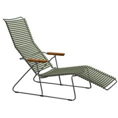 a green lawn chair with a wooden armrest and foot rest on top of it