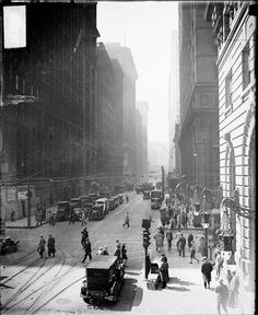 an old black and white photo of people on the street