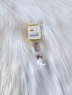 a white furry surface with a badge holder on it's side and a metal clip in the middle