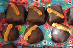 chocolate covered candies with orange peels on a blue and pink flowered cloth