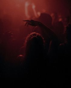 a person holding their hand up in the air at a concert