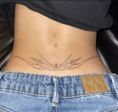 a woman's stomach with an intricate tattoo on her lower back and the bottom part of her abdomen