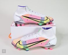 a pair of nike soccer cleats are displayed on a white box with pink, yellow and blue accents