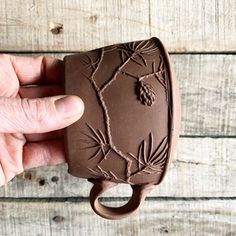 a hand holding a chocolate cup with designs on it