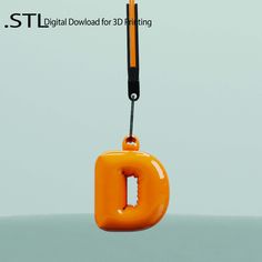 an orange object hanging from a hook on a gray background with the letter d attached to it