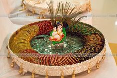 an elaborately decorated glass bowl on display at a wedding ceremony in india, depicting the god ganesh