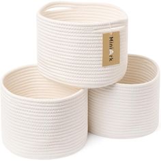 three white rope baskets stacked on top of each other, one with a gold label