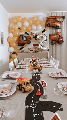 a long table with cars and balloons on it