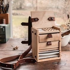 a wooden box that has some kind of tool in it on a table with other items