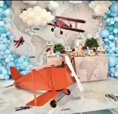 an airplane is on display in front of a wall with balloons and streamers around it