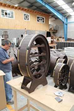 a man standing next to some wooden barrels