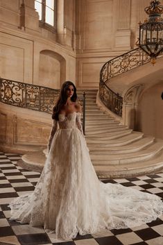 a woman in a wedding dress standing on a checkered floor with stairs behind her