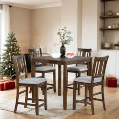 a dining room table and chairs in front of a christmas tree