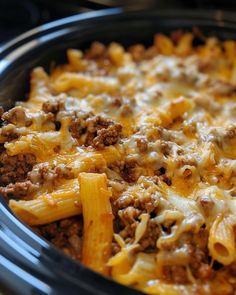 a crock pot filled with pasta and ground beef