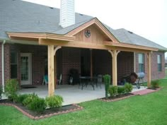 a patio covered in wood and surrounded by grass