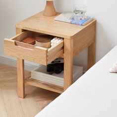 a small wooden table with two drawers on one side and a lamp on the other