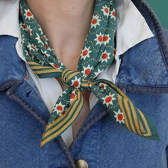 a close up of a person wearing a blue jacket with a tie around their neck