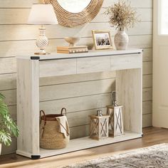 a white console table with two baskets and a mirror on the wall above it in a living room