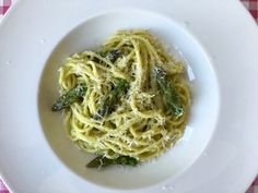 a white plate topped with pasta and asparagus