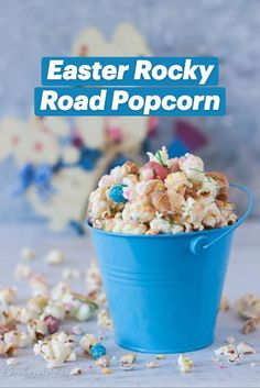 a blue bucket filled with popcorn and sprinkles on top of a table