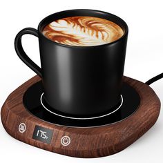 a cup of coffee sitting on top of a wooden coaster with an electronic clock underneath it