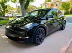 a black tesla parked on the side of a street