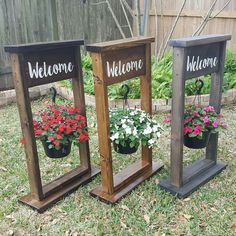 three wooden planters with flowers in them on the grass