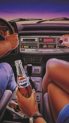 two people sitting in the driver's seat of a car, one holding a beer