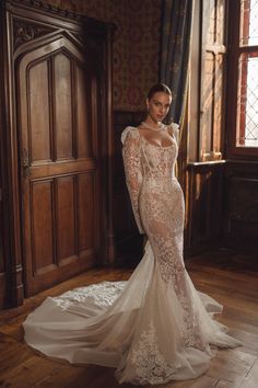 a woman in a wedding dress standing on a wooden floor next to a door and window