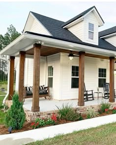 a white house with porches and rocking chairs on it's front lawn area