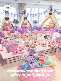 a room filled with lots of pink and purple items on top of a white table