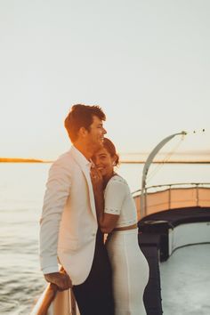 a man and woman standing next to each other on a boat