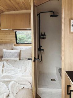 the interior of an rv with a bed and shower in between it's walls