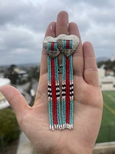 a hand holding some beads in it's palm with the sky in the background