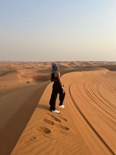 a person standing on top of a sand dune