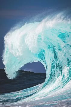 a large blue wave crashing into the ocean