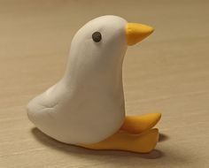 a white and yellow bird sitting on top of a wooden table