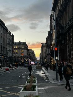 people are walking down the street at sunset