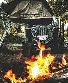 a jeep is parked next to a campfire