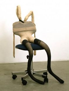 a chair that is sitting on top of a desk with a stuffed animal in it's back