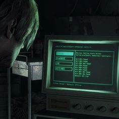 a man looking at a computer screen with green light coming from the monitor's screen