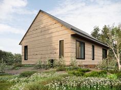 a small wooden house sitting on top of a lush green field