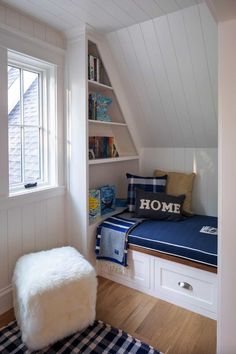 a room with a window seat and bookshelf in the corner next to it