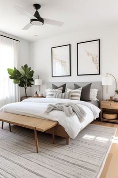 a bedroom with a bed, nightstands and two pictures on the wall above it