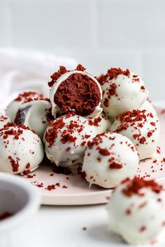 chocolate truffles with white frosting and sprinkles on a plate