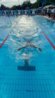 a person swimming in a pool with people watching