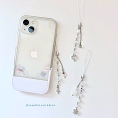 an iphone case with some charms attached to it